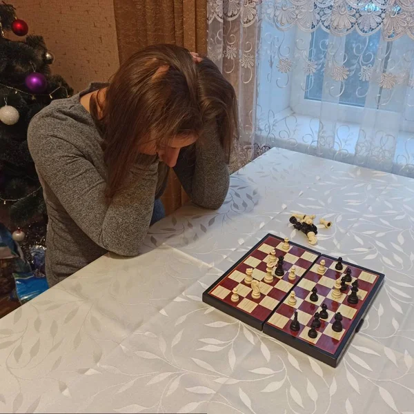 心烦意乱的欧洲女人在桌边下棋 — 图库照片