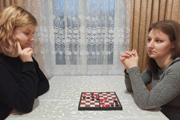 两个女孩在桌上玩跳棋游戏 — 图库照片