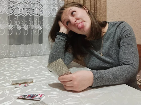Ευρωπαϊκή Γυναίκα Παίζει Χαρτιά Και Κολλήσει Έξω Γλώσσα Στο Τραπέζι — Φωτογραφία Αρχείου