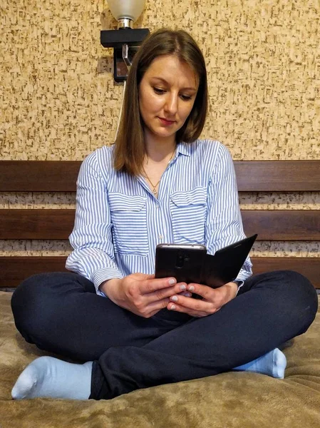 Συγκεντρωμένη Ευρωπαϊκή Γυναίκα Κάθεται Στο Κρεβάτι Και Χρησιμοποιήσετε Smartphone Στο — Φωτογραφία Αρχείου