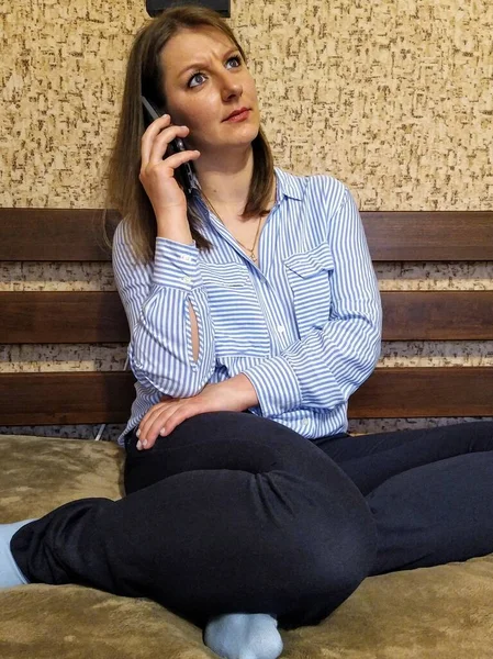 Överraskad Europeisk Kvinna Sitta Sängen Och Prata Smartphone Sovrummet Hemma — Stockfoto