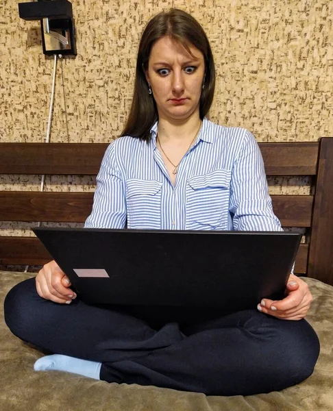 Överraskad Europeisk Kvinna Sitta Sängen Och Använda Laptop Dator Sovrummet — Stockfoto