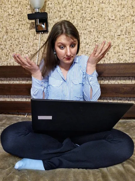 ストレスの多いヨーロッパの女性はベッドに座って 自宅で寝室でラップトップコンピュータを使用します — ストック写真