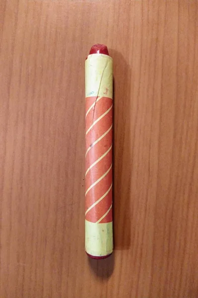 Red art pencil on wooden background