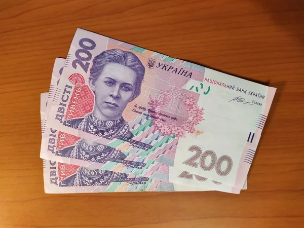木制背景下的两百格里夫尼亚钞票 — 图库照片