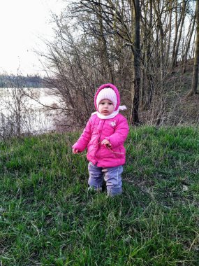 Küçük kız bahar mevsiminde kırsal kesimde gün batımında parkta oynuyor.