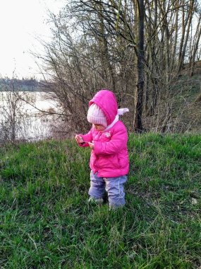 Küçük kız bahar mevsiminde kırsal kesimde gün batımında parkta oynuyor.