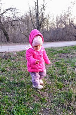 Küçük kız bahar mevsiminde kırsal kesimde gün batımında parkta oynuyor.