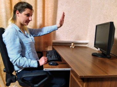 Avrupalı genç bir kadın masada oturur, video görüşmesi yapar ve evdeki bilgisayarda beşlik çakar.