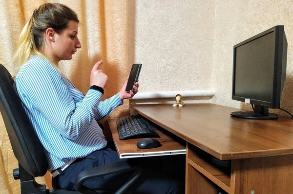 欧洲的年轻女子坐在桌旁 在家里用智能手机进行视频通话和摆出姿势 — 图库照片