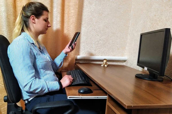유럽의 여성은 테이블에 앉아서 집에서 스마트폰으로 비디오 통화를 합니다 — 스톡 사진