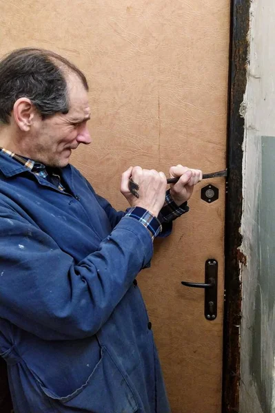 欧洲成年工人用撬棍开门 — 图库照片