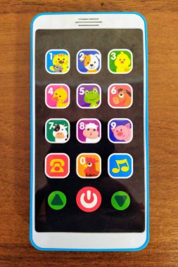 Ahşap masa arkasında çocuksu müzik akıllı telefon
