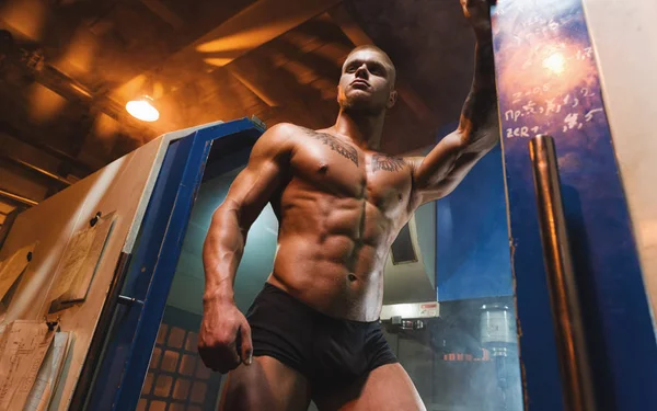 Genç vücut geliştirmeci ve fabrika