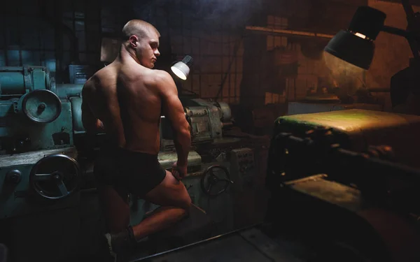 Genç vücut geliştirmeci ve fabrika