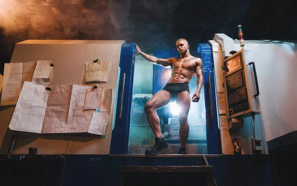 Genç vücut geliştirmeci ve fabrika