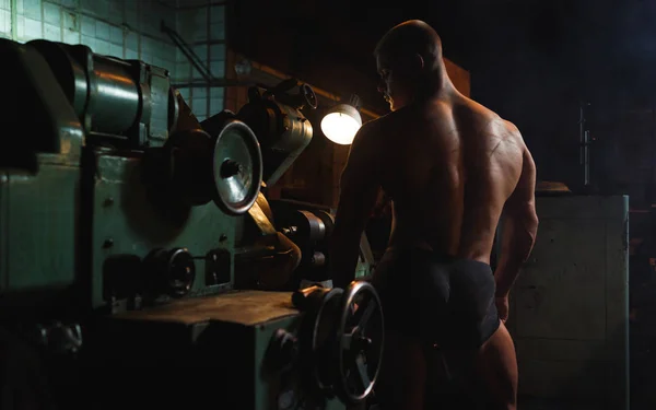 Genç vücut geliştirmeci ve fabrika