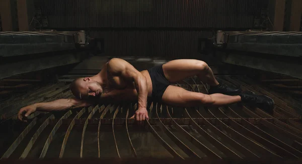 Genç vücut geliştirmeci ve fabrika