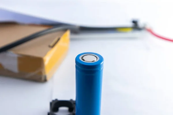 Blue lithium ion battery which placed vertically with blurred background.