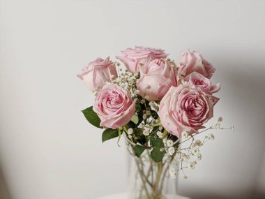 İçinde bir buket gül ve vazoda kurumuş kır çiçekleri olan minimum kompozisyon. Bahar konsepti Sevgililer Günü. Düğün Günü.