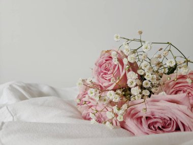 Pamuk tekstil üzerinde bir buket gül ve kurumuş kır çiçekleriyle en düşük kompozisyon. Bahar konsepti Sevgililer Günü. Düğün Günü.