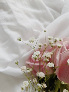 Kurumuş kır çiçekleriyle en düşük bileşim kapanıyor ve pamuk tekstil üzerinde güller tomurcuklanıyor. Bahar konsepti Sevgililer Günü. Düğün Günü.