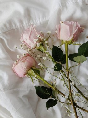 Pamuk tekstil üzerinde bir demet gül ve kurumuş kır çiçekleriyle en düşük kompozisyon. Bahar konsepti Sevgililer Günü. Düğün Günü.