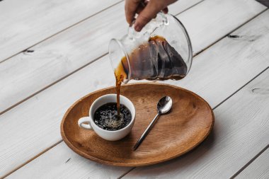 Ahşap masa üzerinde kaşıkla kahve