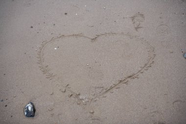 Sahilde, kumsalda, sevgi dolu bir kalp çizildi.