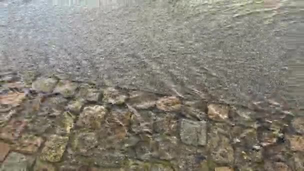 홍수가 났을 때, 물은 거센 바람을 타고 산책로를 빠르게 흐른다 — 비디오