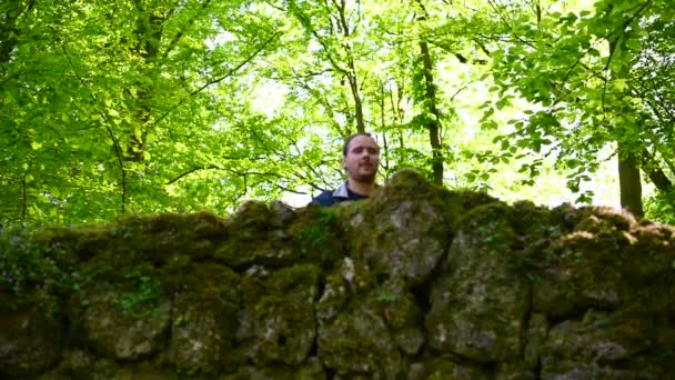 Мужчина Смотрит Большую Старую Каменную Стену Большими Маленькими Камнями Покрытыми — стоковое видео