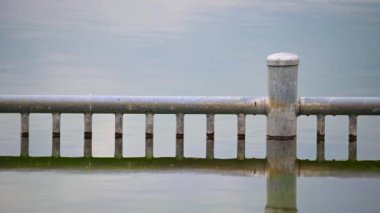 Kuzey Almanya 'da bulutlu gökyüzü ve sakin su ile kıyıdan gelen yüzemeyenler için özel bir yansıtıcı işaretle taş ocağı göleti manzarası