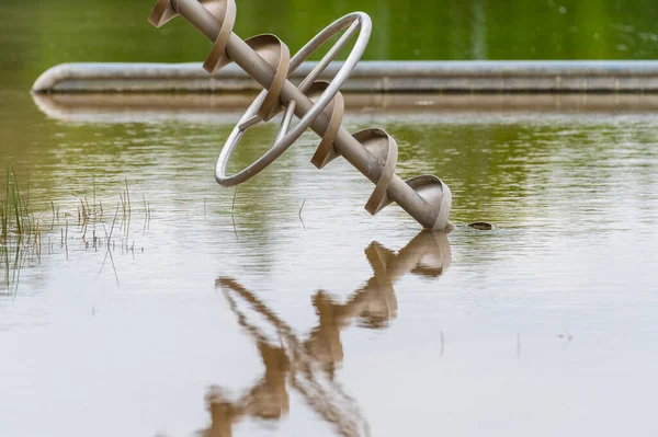 view of an excavated  lake with a special focus on a reflective toy for children that can carry water from the shore with overcast skies and calm water in northern Germany