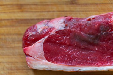 Dilimlenmiş taze bir biftek ve ahşap bir tahtanın üzerinde yağlı biftek.