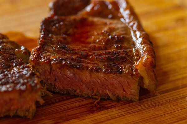 Shots of a sliced fresh rump steak with fat on the steak on a wooden board