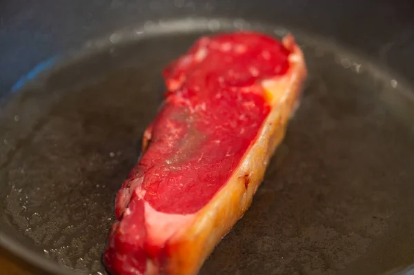 火锅里放着一片生鲜的肥肉排骨 牛排在高温下烤透了 — 图库照片
