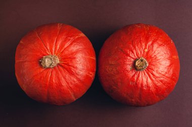 Kahverengi arkaplanlı bir balkabağı resmi ve mesaj için bir yer. Değişken mevsimlik balkabakları.