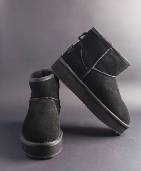 Black suede uggs. Stock photo on a black background.