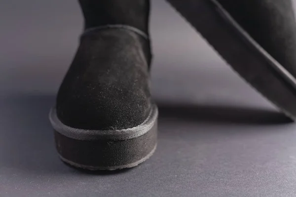 Black suede uggs. Stock photo on a black background.