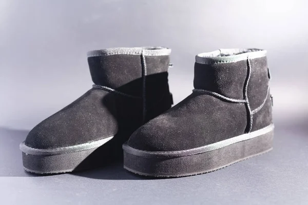 Black suede uggs. Stock photo on a black background.