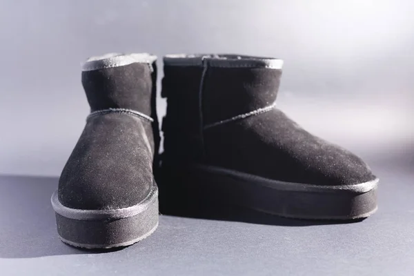 Black suede uggs. Stock photo on a black background.