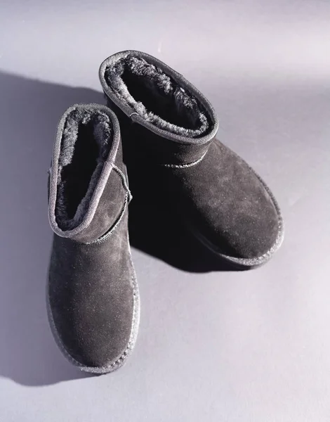 Black suede uggs. Stock photo on a black background.