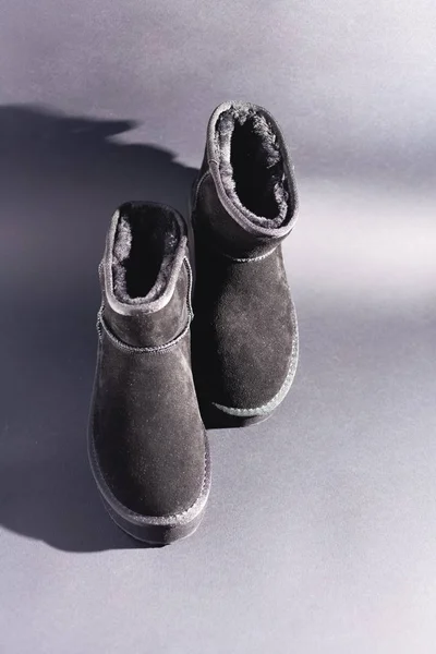 Black suede uggs. Stock photo on a black background.