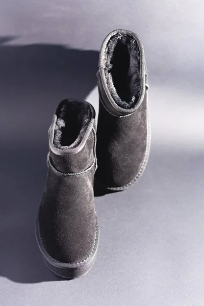 Black suede uggs. Stock photo on a black background.