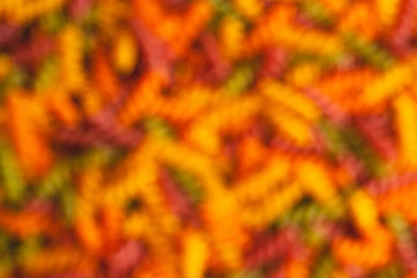 Uncooked tricolore fusilli pasta twist shapes background. Stock photo pasta twist shapes.
