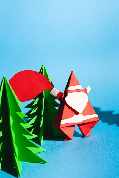 Origami santa claus with a bag of gifts. Cartoon postcard. Stock photo handmade paper.