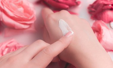 Spa Salonu: Pembe Güller ve Gül Yapraklı Su Kasesinde Fransız Manikürlü Güzel Kadın Elleri.