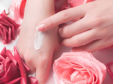 Spa Salonu: Pembe Güller ve Gül Yapraklı Su Kasesinde Fransız Manikürlü Güzel Kadın Elleri.