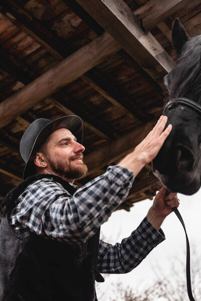 Портрет парня в шляпе с черной лошадью
.