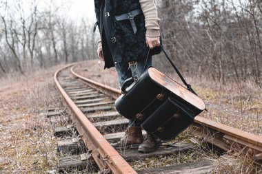 Demiryolunda süet sonbahar botları giyen bir adam. Yürüyüş, seyahat pratik kıyafetler, ayakkabılar..